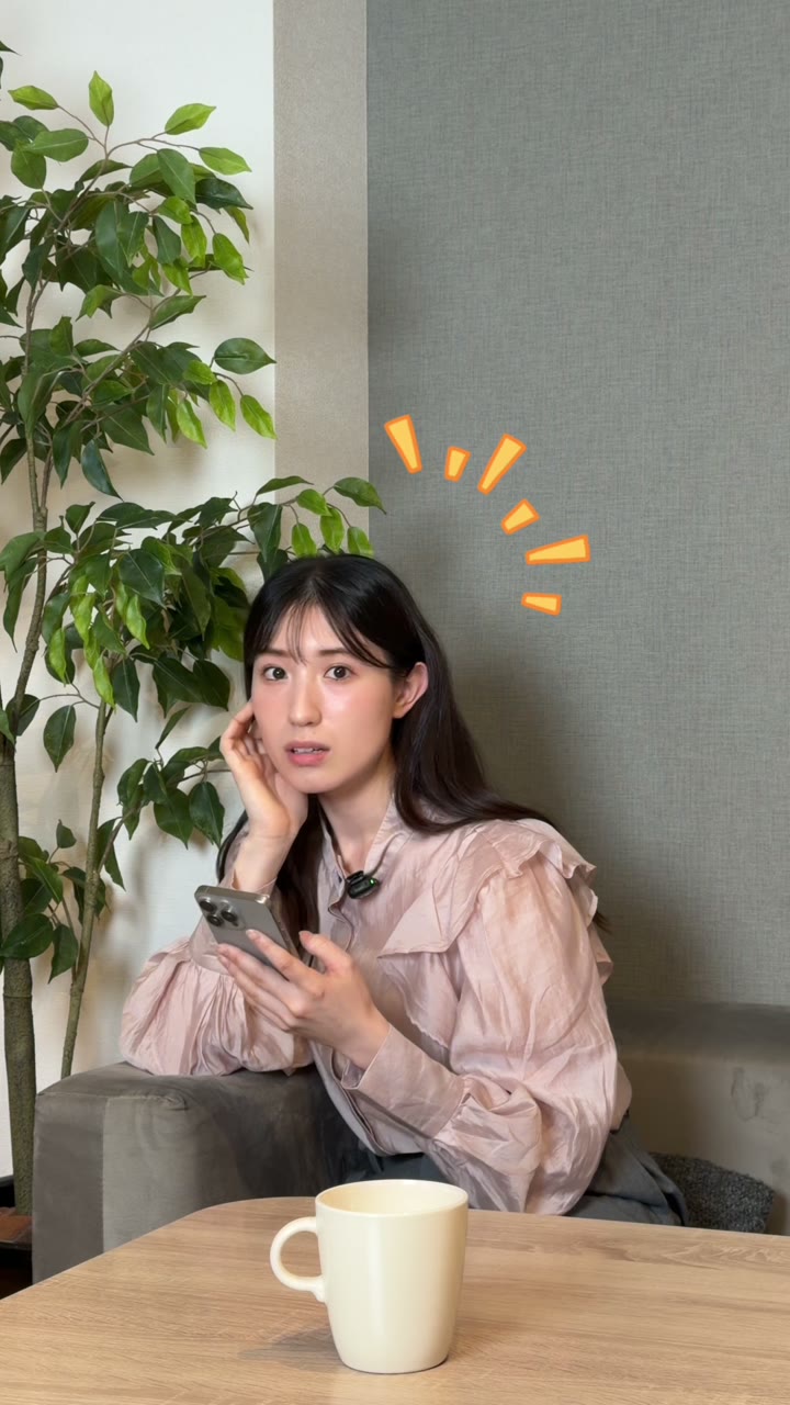 A woman holding a phone at a table in a Dola ad about résumé photos